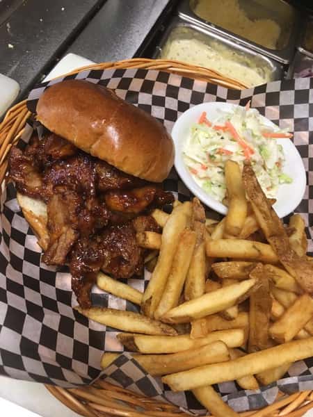 a burger with barbeque sauce, a side of coleslaw and fries