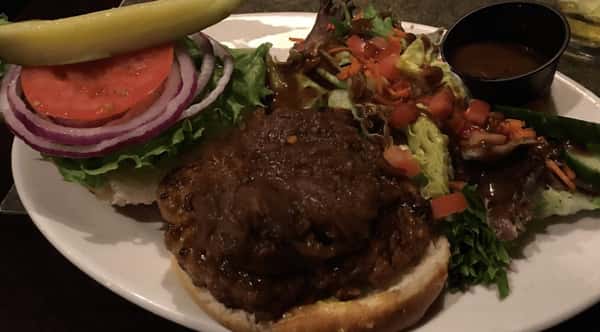 a burger with lettuce, tomato and onion.