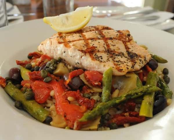 grilled salmon on top of assorted roasted veggies