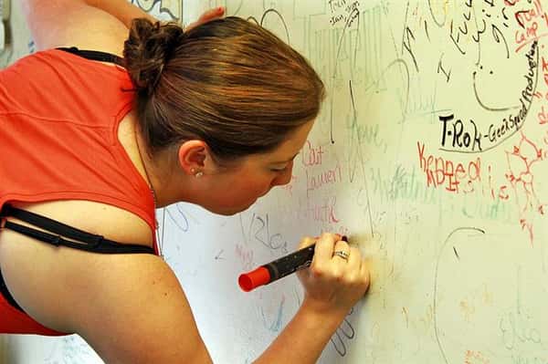 woman drawing on the walls of backyard bbq pit
