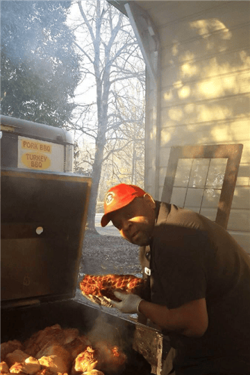pitmaster putting meat on the smoker outside