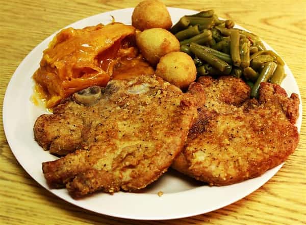 fried fish entree with vegetables and hush puppies