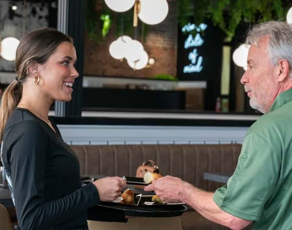Server with tray serving customer