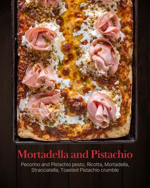 Meet the Mortadella and Pistachio. ✨ Pecorino and Pistachio pesto, Ricotta, Mortadella, Stracciatella, and Toasted Pistachio crumble — every layer is doing something. It's bold, it's fresh, and it's made entirely from scratch. Order online or stop in and try it yourself.