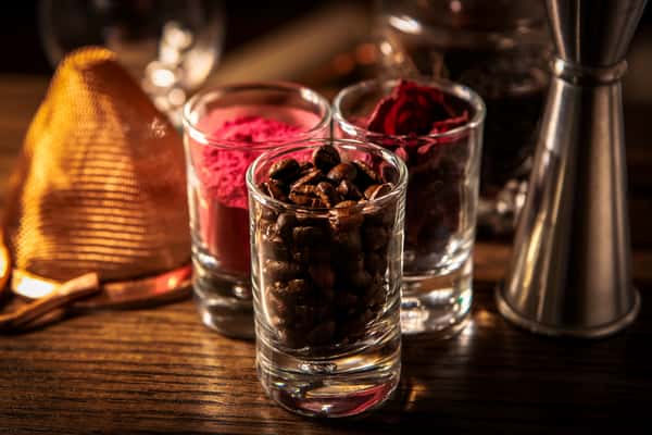 Cocktail garnish ingredients including dried citrus, botanicals, and spices arranged on a bar top for craft drinks.
