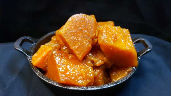 Glazed candied yams side dish served in a mini cast iron skillet at Southern Blues.