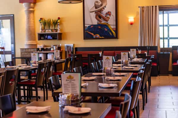 Warm and welcoming Mexican restaurant dining room with neatly set tables, comfortable booths, and traditional Southwestern décor.