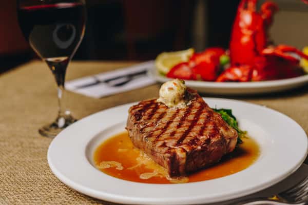 steak with broiled lobster in background