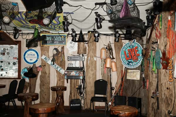 Wall of coastal bar décor with fishing gear, signs, nets, and stage lighting at Stinky's Bait Shack in Santa Rosa Beach, Florida.