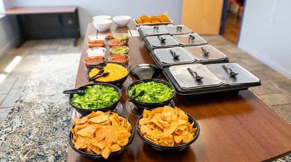 Long wooden table with catering ingredients organized on top
