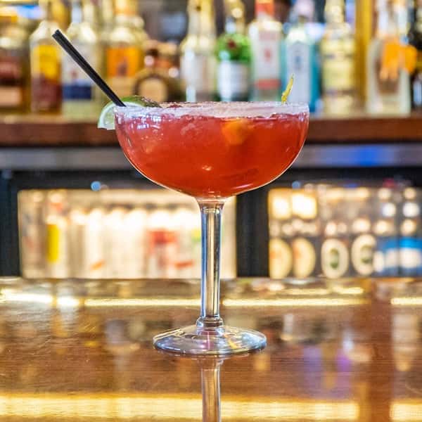 red cocktail in stemmed glass