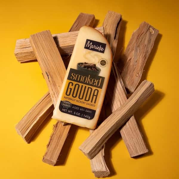 A wedge of Marieke smoked gouda on a yellow background