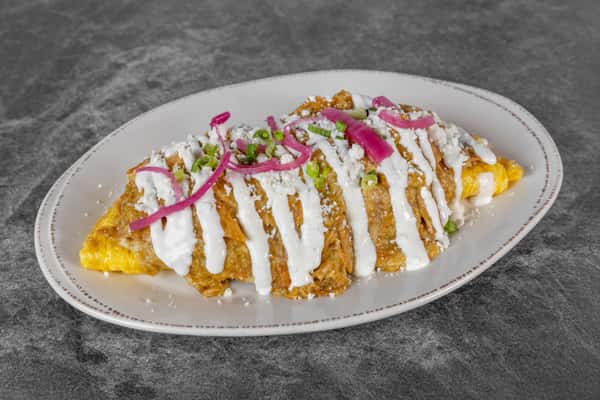 Golden breakfast dish topped with a generous drizzle of white sauce, thinly sliced red onions, fresh herbs, and colorful garnishes, served on a white plate.