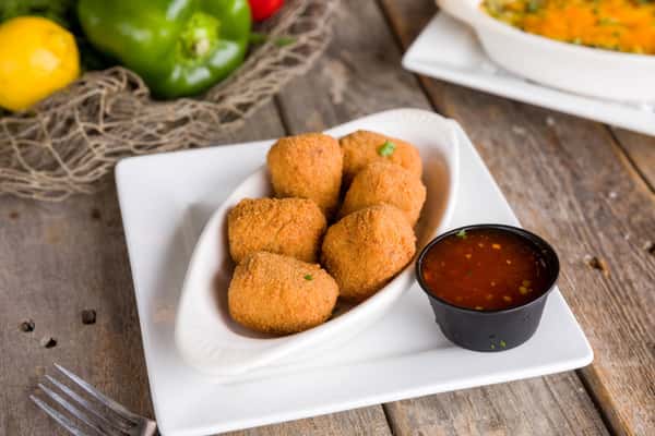 Breaded fried cheese bites served with sweet chili dipping sauce, casual appetizer with crispy golden coating