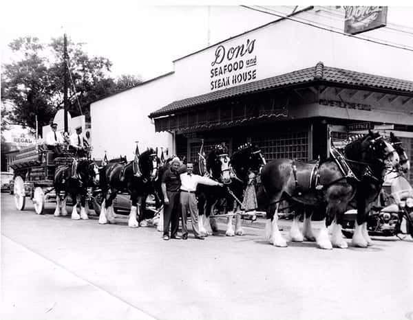 Vintage black-and-white photo of Don's Seafood and Steak House exterior with a team of draft horses and carriage parked outside, capturing historic Louisiana restaurant heritage