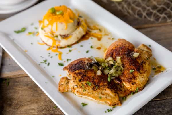 Blackened grilled chicken breast topped with relish, served with a side of mashed potatoes, Southern-style entrée