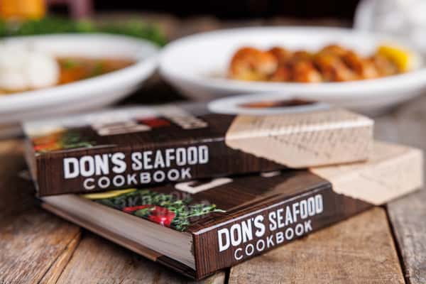 A stack of two Don's Seafood Cookbooks