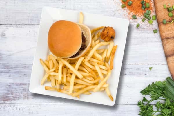 Cheeseburger with a soft bun served alongside golden French fries and hush puppies, casual diner-style meal