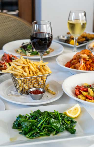 A lively table spread featuring golden fries, pasta, and refreshing drinks, capturing the essence of a shared, indulgent meal.
