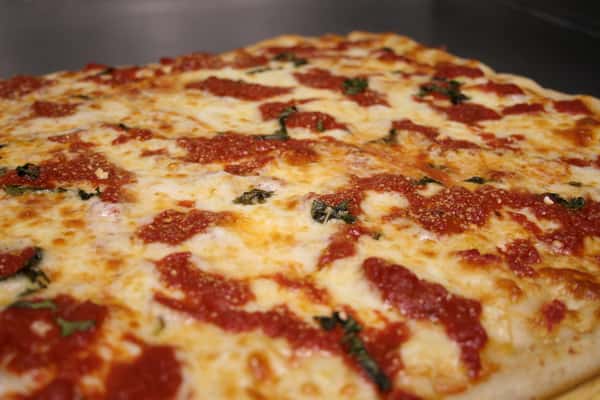Grandma style pizza with cheese, sauce, and basil