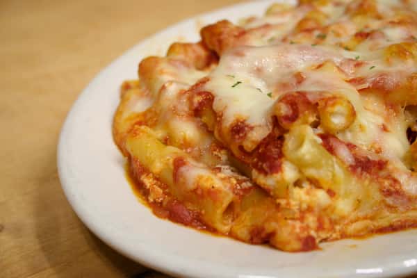Baked ziti topped with red sauce and melted mozzarella