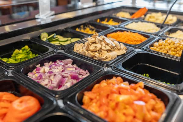 prep bar of pizza toppings