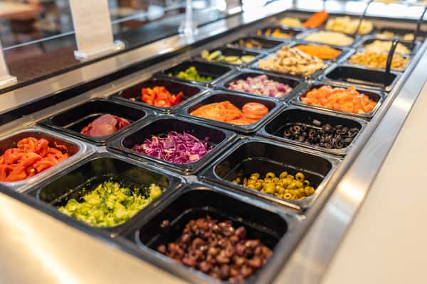 prep bar of pizza toppings