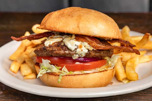 Bacon cheeseburger with lettuce, tomato, onion, and blue cheese crumbles, served with golden French fries.