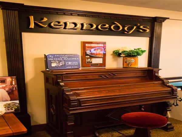 piano with a sign that reads kennedy's above it