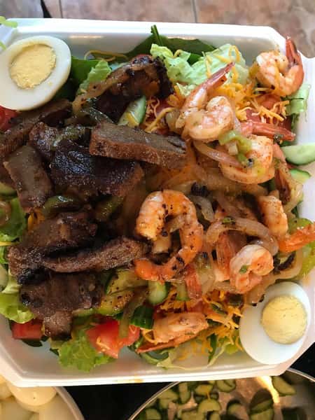 salad topped with shrimp and beef