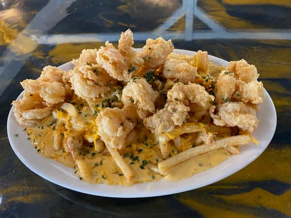 fried shrimp over fries with sauce