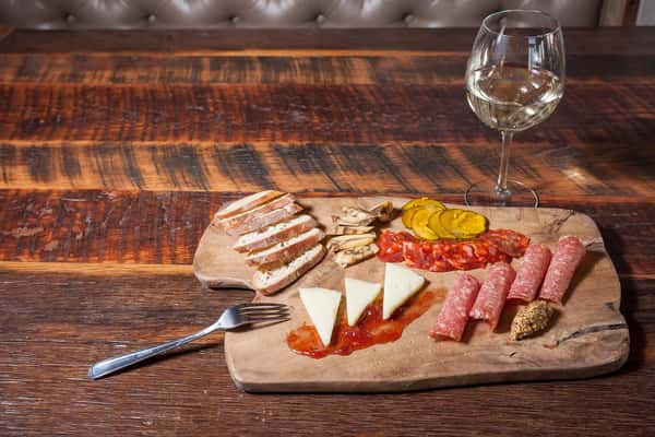 charcuterie board with glass of wine