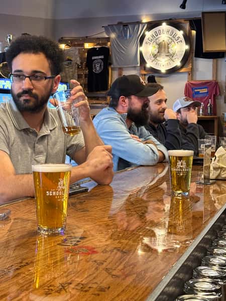 Guests at the Schoolhouse Brewing bar in Marietta with fresh pints of beer in Schoolhouse glassware