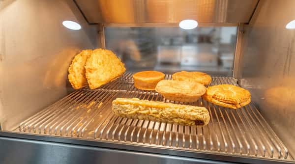 Freshly cooked chip shop favourites displayed under heat lamps at Blue Bay.