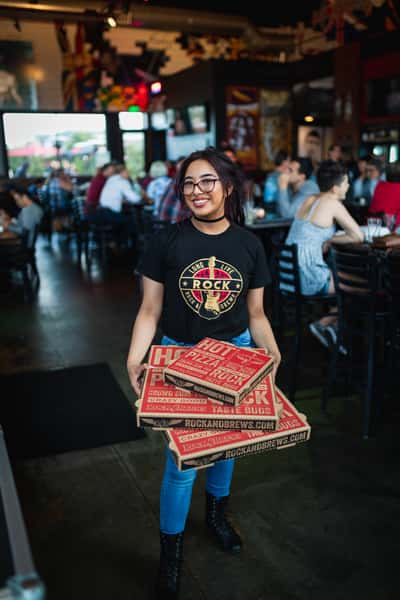 Rock & Brews waitress holding pizza boxes