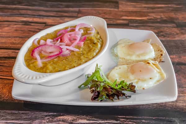 Traditional Dominican mangú with sautéed red onions, served alongside two fried eggs and fresh greens—classic Caribbean breakfast plate.