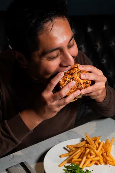 person eating a burger at a table