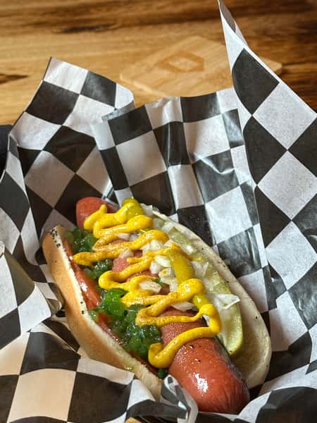 Jumbo Vienna Beef Hot Dog, yellow mustard, tomato slices, sport peppers, Chicago relish, celery salt, chopped onions, & dill pickle spear, on a poppy seed bun.