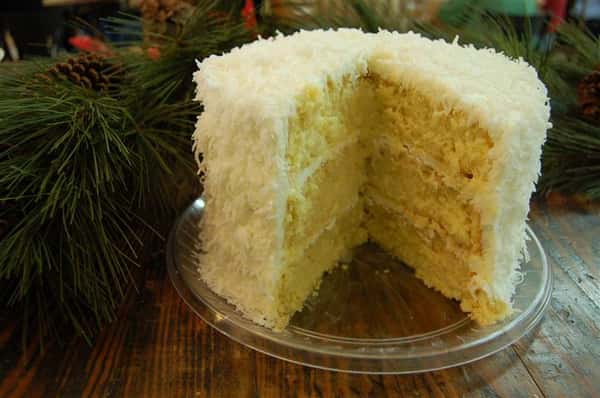 Three layer cake with coconut on the outside.