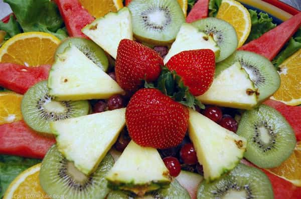 Close up of fruit platter with kiwi, strawberries and pineapple, orange and watermelon.