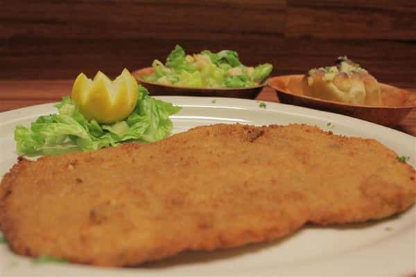 Chicken Milanese plate. Small Caesar salad and garlic knots on the side.