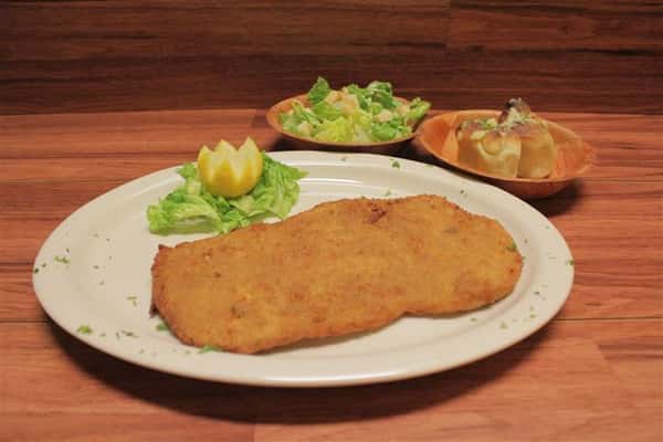 Chicken Milanese plate. Small Caesar salad and garlic knots on the side.