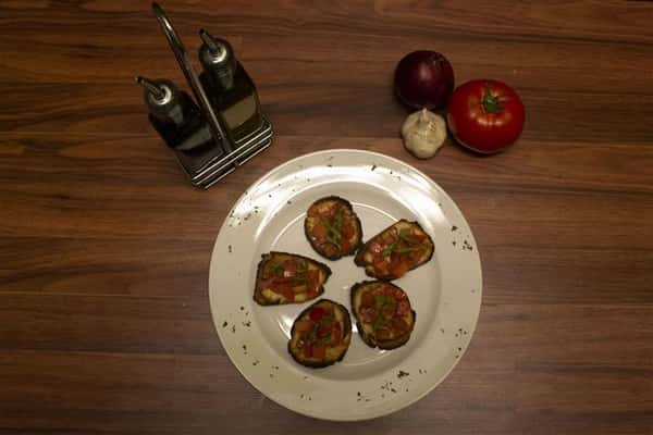 Top view of Bruschetta. Olive oil, garlic, onion and tomato on the side.