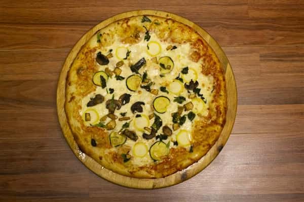 Top View of Giardino Pizza. Pizza topped with tomato sauce, mozzarella, eggplant, spinach, yellow squash, zucchini & mushrooms.