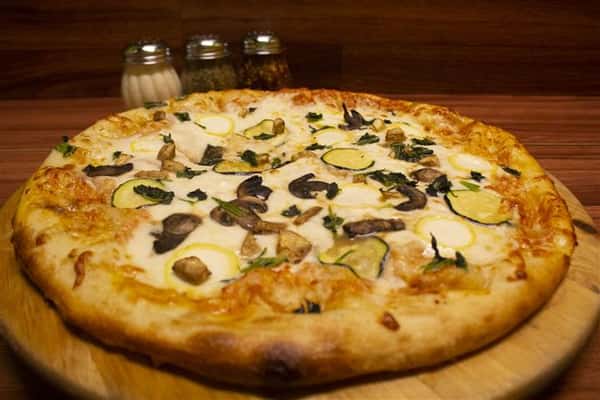 Side View of Giardino Pizza. Pizza topped with tomato sauce, mozzarella, eggplant, spinach, yellow squash, zucchini & mushrooms.