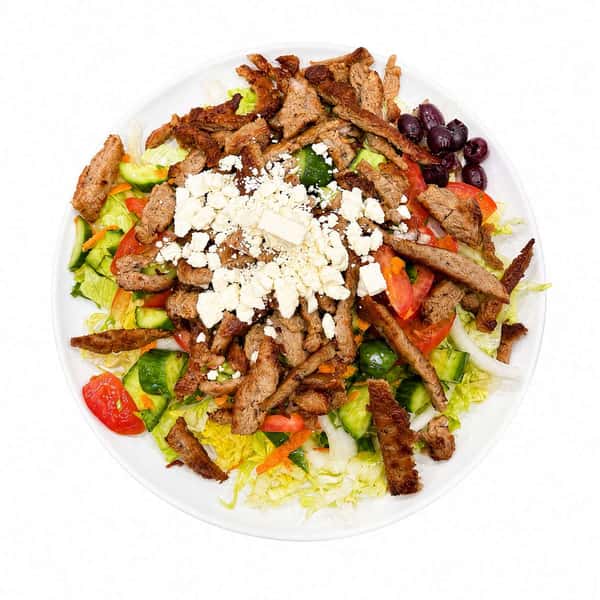 Greek salad topped with seasoned gyro meat, crumbled feta cheese, Kalamata olives, cucumbers, tomatoes, and crisp lettuce for a fresh Mediterranean meal.