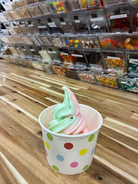 Strawberry cheesecake frozen yogurt parfait layered with fresh strawberry sauce and graham cracker crumble in a clear cup – sweet, tangy dessert perfect for a froyo bar topping station.