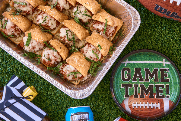 Green turf background with appetizer platter and game time plates