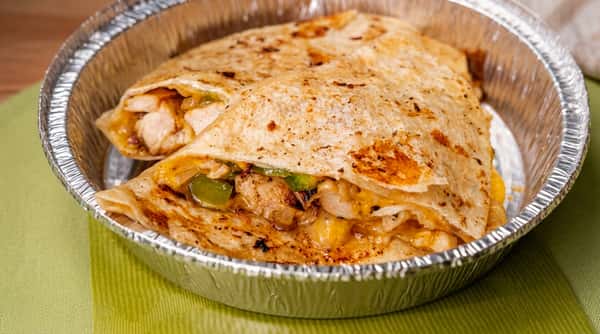 Chicken quesadilla with melted cheese and bell peppers, served in a foil container.