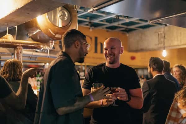 two men laughing with drinks